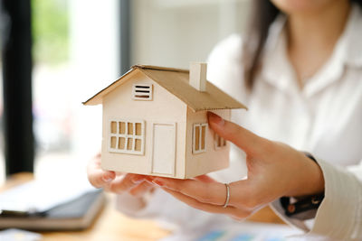 Midsection of woman holding model home