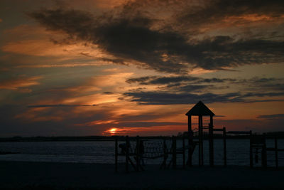 Volleyball net and monkey bars at beach during sunset