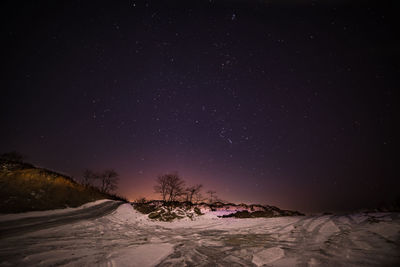 Scenic view of snow covered landscape against sky at night