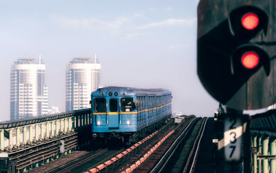 Train on railroad tracks in city against sky