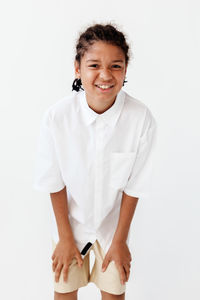 Portrait of smiling young woman holding dentures against white background