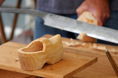 Dutch clog maker crafting wooden clogs in workshop