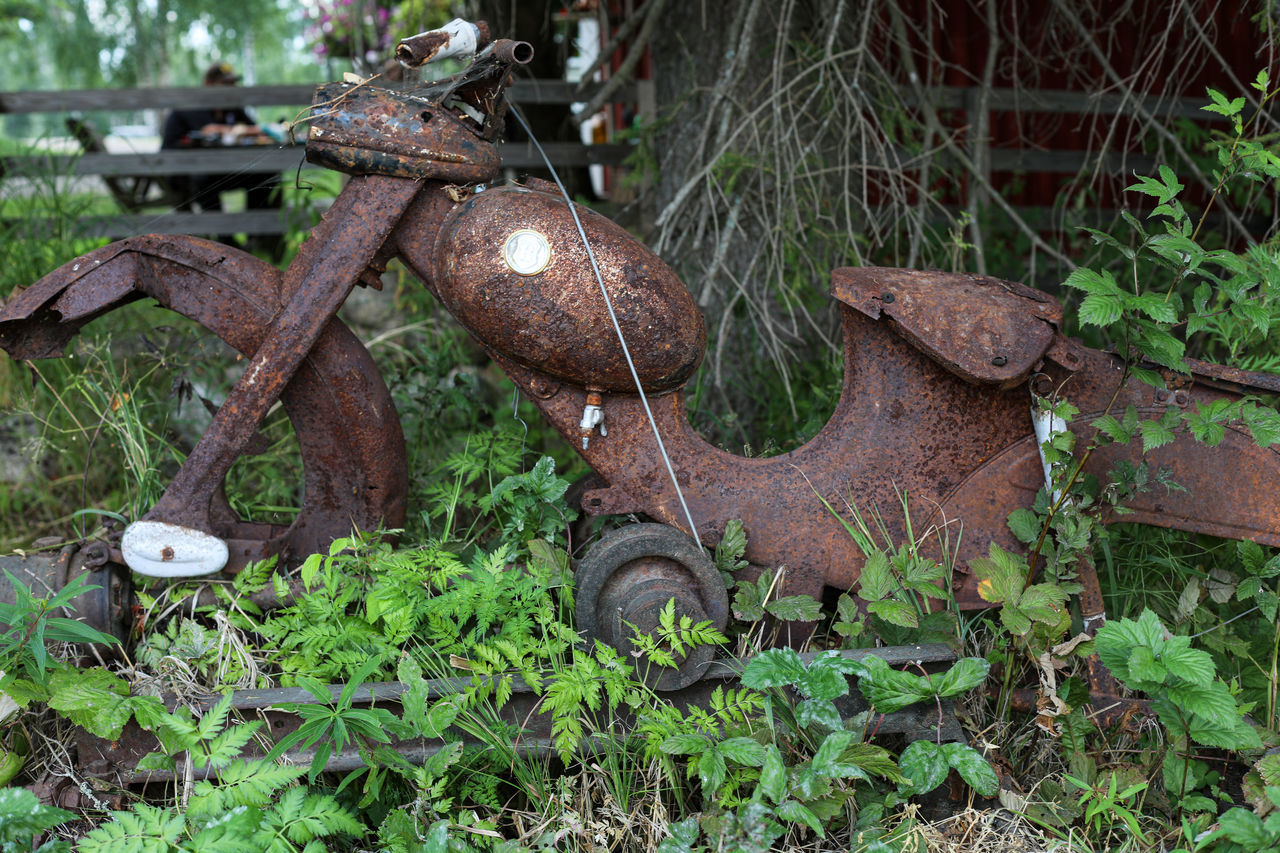 OLD RUSTY WHEEL ON FIELD BY ROAD