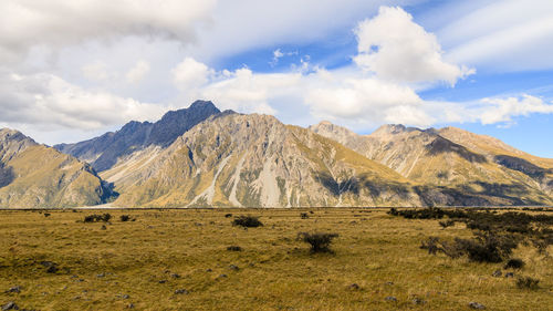 Scenic view of field and mountains against sky