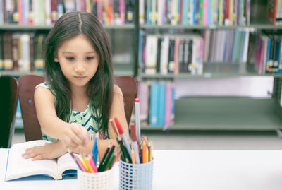 Portrait of a girl sitting on book