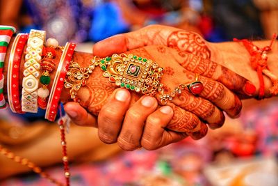 Cropped image of couple holding hands during wedding ceremony