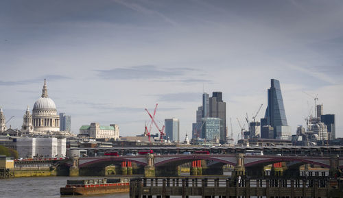 View of cityscape against cloudy sky