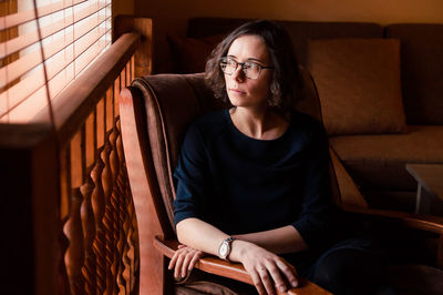 Young woman sitting on sofa at home