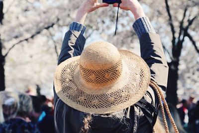 Rear view of person holding hat