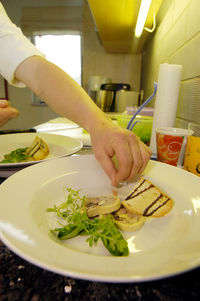 Midsection of person preparing food in plate