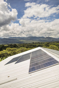 Solar panels await installation on rooftop of rural building.