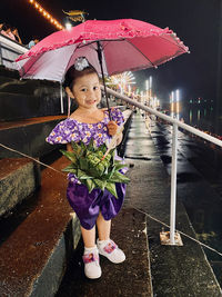 Portrait of a girl with umbrella standing in rain