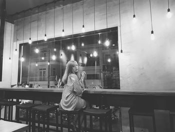 Woman sitting in illuminated room