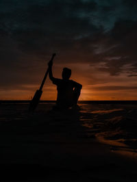 Silhouette man at beach during sunset