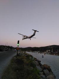 Helicopter flying over sea against clear sky