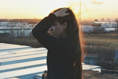 Woman standing against sky during sunset