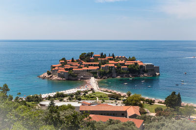 High angle view of buildings by sea against sky