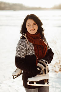 Smiling woman standing on snow covered field