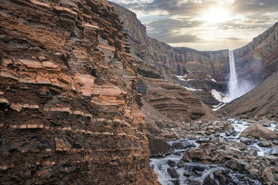 View of beautiful cascades of hengifoss falling from mountains against sky