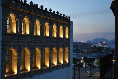 Illuminated building against sky at dusk