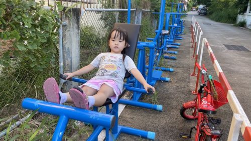 Cute girl sitting on slide at playground