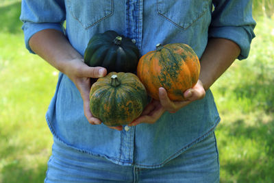 Midsection of man holding pumpkin