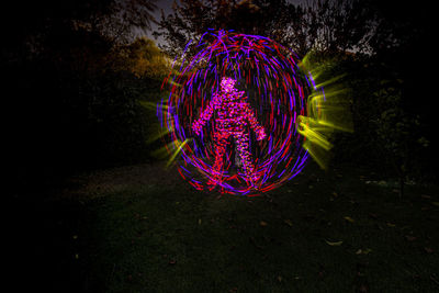 Illuminated light painting on field at night