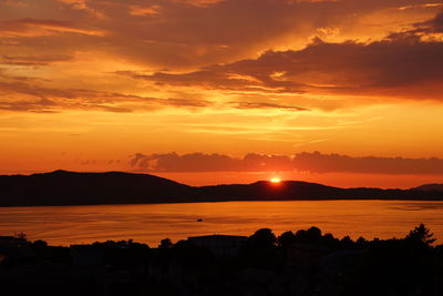 Scenic view of silhouette mountains against romantic sky at sunset