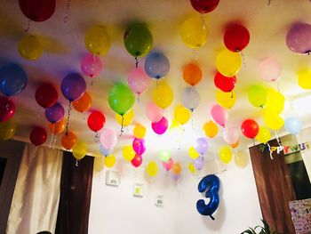 Low angle view of multi colored balloons hanging on ceiling