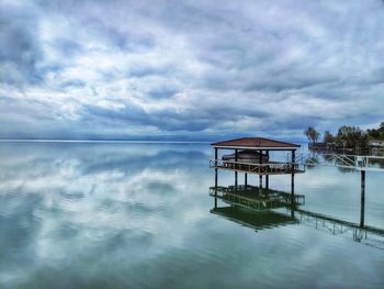 Storm clouds building over the lake. dramatic reflection in still water. boathouse contrast.