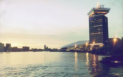 Illuminated buildings in city at waterfront