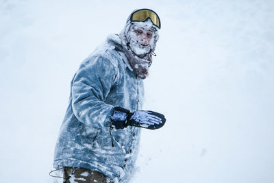 Low angle view of man in snow against sky