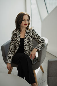 Young woman sitting on sofa at home