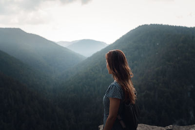 Rear view of woman standing against mountain