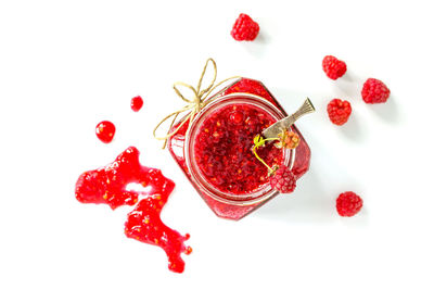 High angle view of red berries against white background