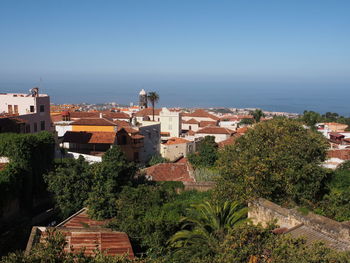 Town by sea against clear blue sky