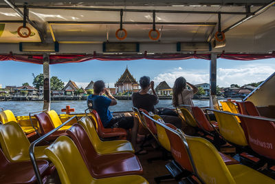 Rear view of people sitting on tourist boat