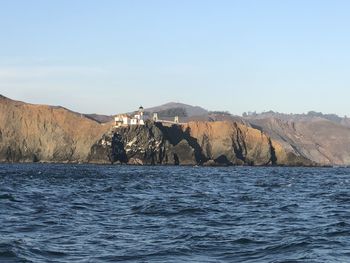 Scenic view of sea and mountains against clear sky