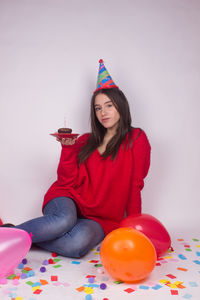 Young woman sitting with balloons