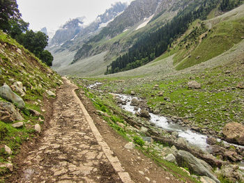 Scenic view of stream amidst mountains against sky