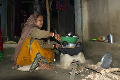 Side view of woman preparing food at home