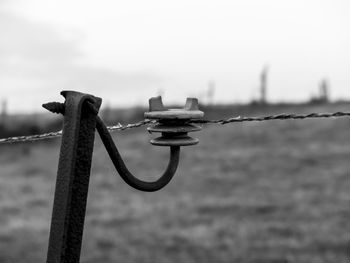 Close-up of rusty metal fence against sky