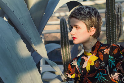 Close up short haired woman near large agave in garden portrait picture