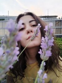 Portrait of woman against pink flowering plants