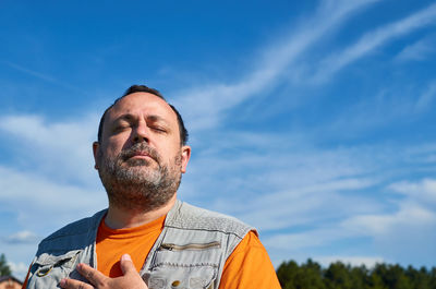 Low angle view of man looking away against sky