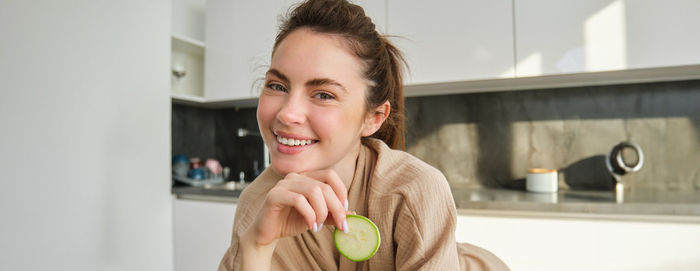 Portrait of smiling young woman sitting at home