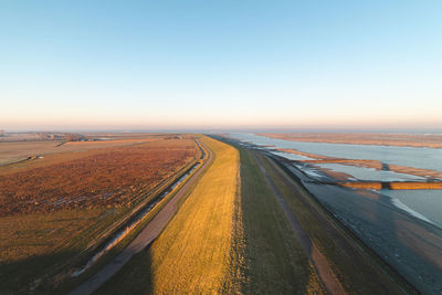 Scenic view of agricultural field against clear sky during sunset