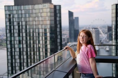 Portrait of young woman standing in city