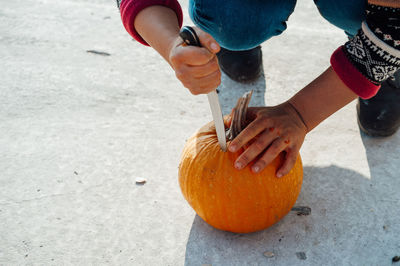 Low section of man holding pumpkin