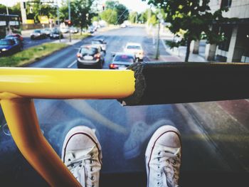 Low section of person wearing white shoes sitting in bus